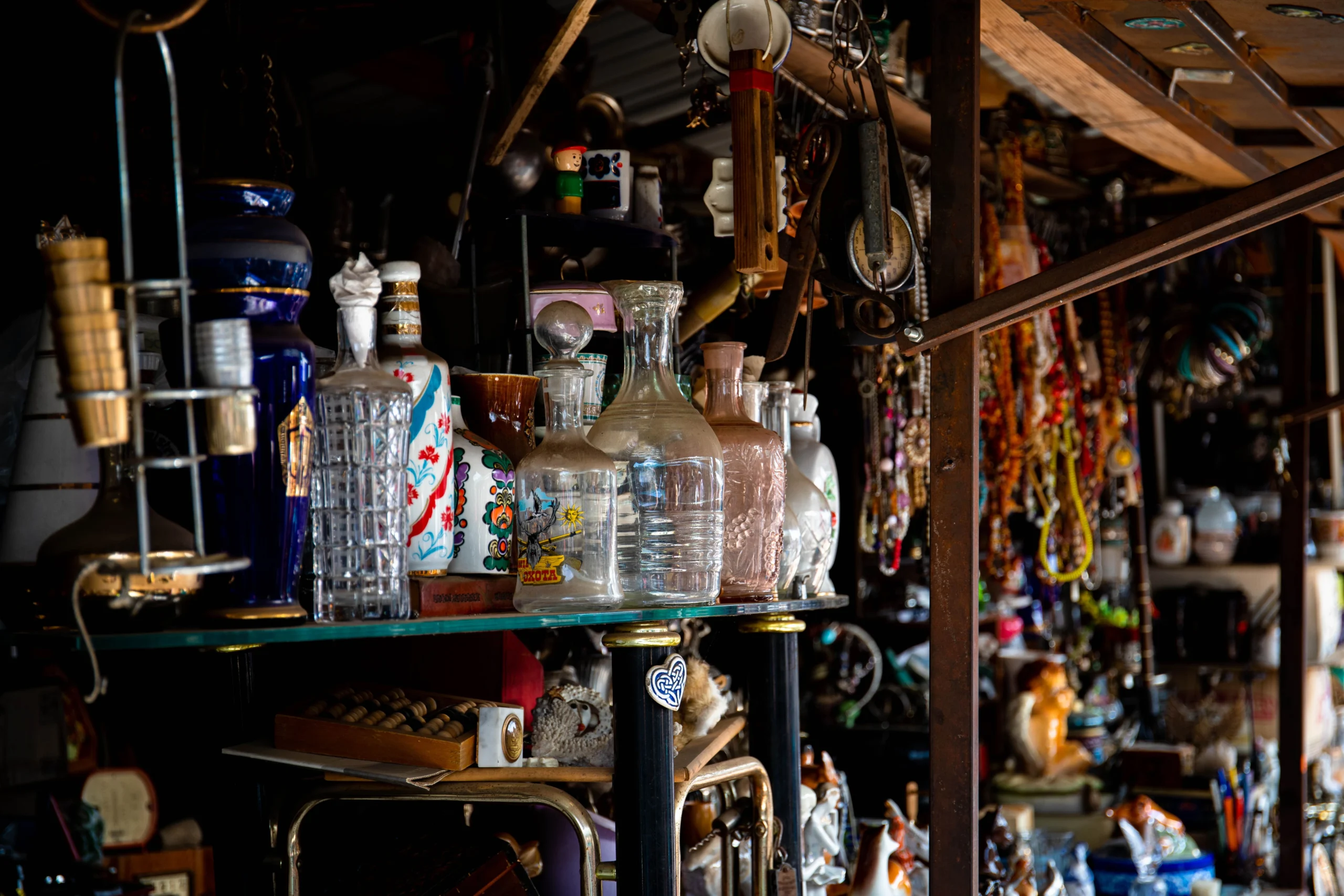eclectic vintage glassware and decor items on shelf in antique shop