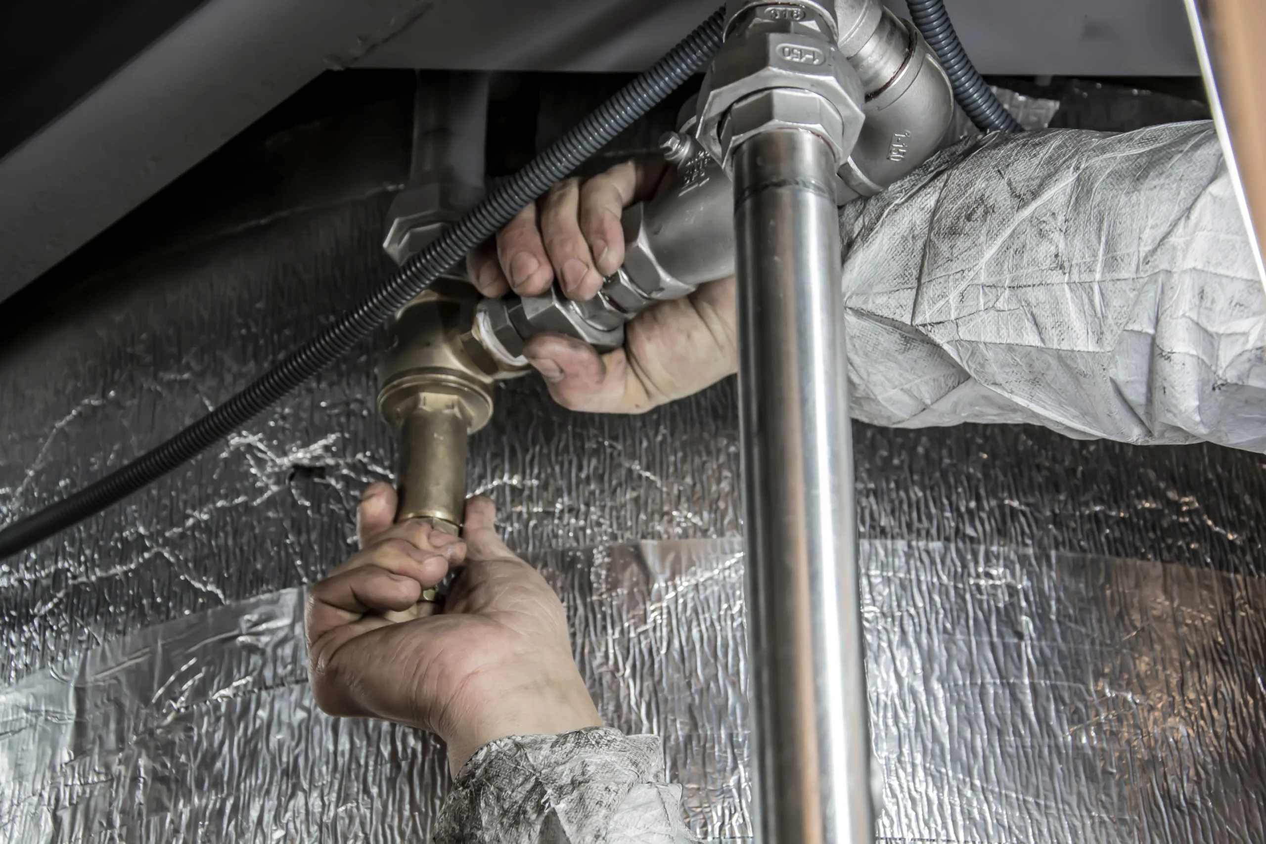plumber installing pipe fittings for water filtration system